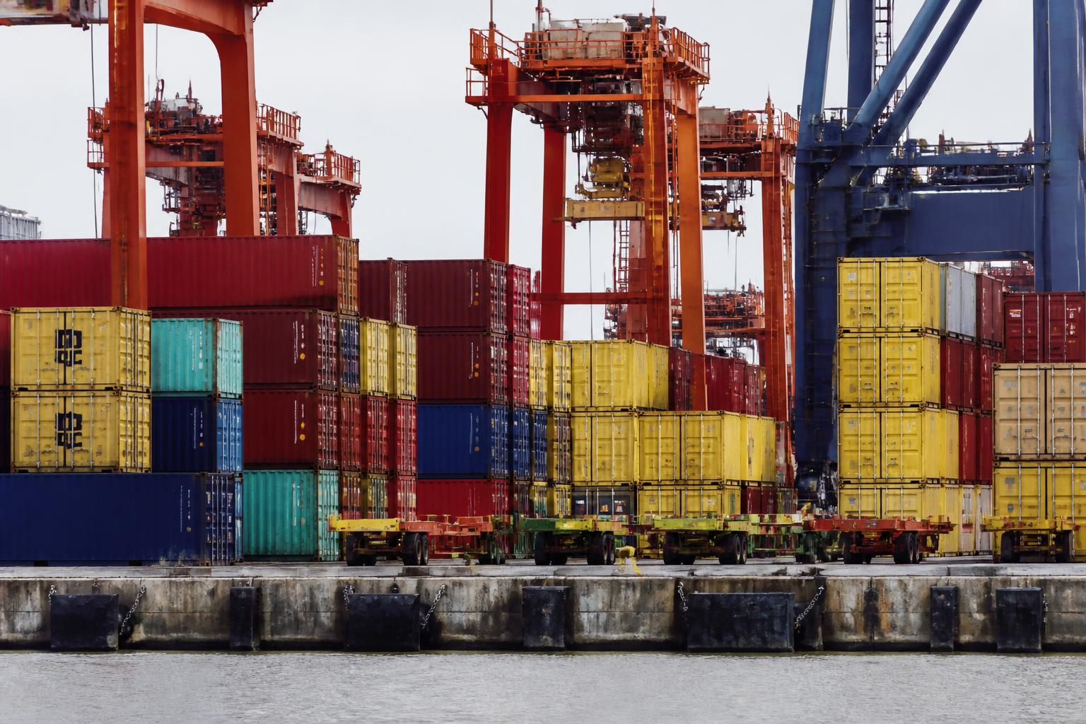 Porto comercial com contêineres de exportação e guindastes