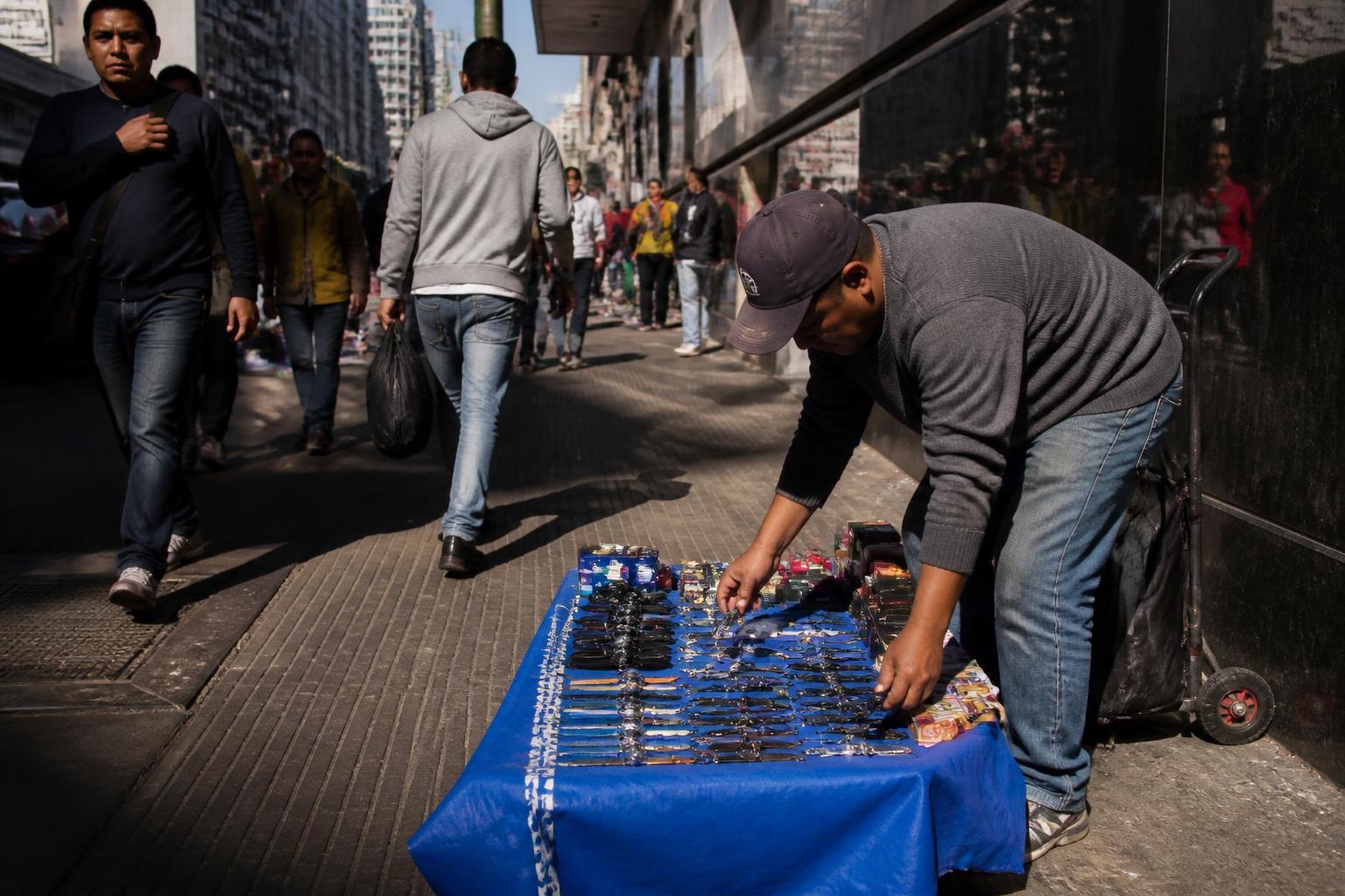 Vendedor informal trabalhando em rua movimentada no Brasil